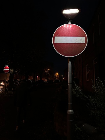 No entry red road sign illuminated at night