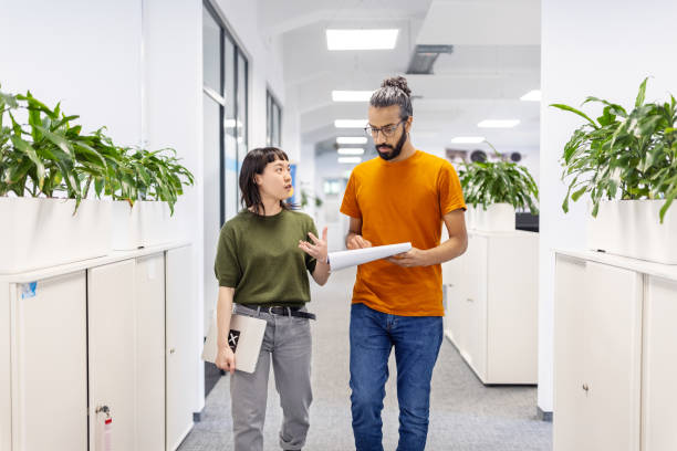 istock Startup business partners walking through office corridor discussing a report 1919289304