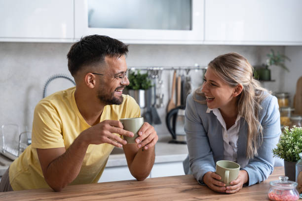 istock Business colleagues talk during lunch break in office kitchen. Woman communicates with workmate hold coffee cups enjoy conversation, discuss work or personal. Good relations at work concept 1919290893