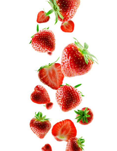 istock Excellently retouched whole and halved strawberries fall into space. Surround light from behind. Isolated on white 1919308940