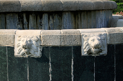 lion head carving in a park, closeup of photo