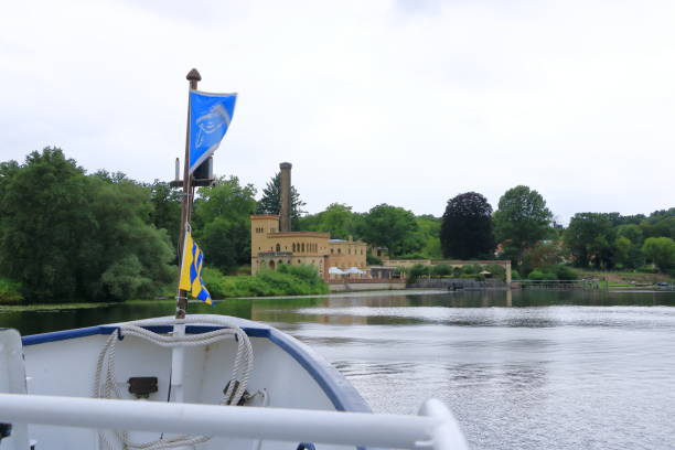 July 31 2023 - Potsdam, Berlin, Brandenburg in Germany: passing the old buildings by boat trip on the Havel River near Glienicke Bridge between Berlin and Potsdam on a cloudy day