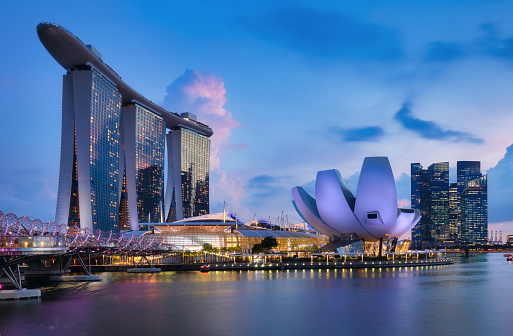 Singapore, September 10, 2020: Apple opened the worlds first floating Apple Store at the Marina Bay in Singapore at the time of this shoot. After a few days it has already become a Singapore landmark. Here the sphere shaped store seen at sunset. Behind the store the skyline of the Singapore financial district.