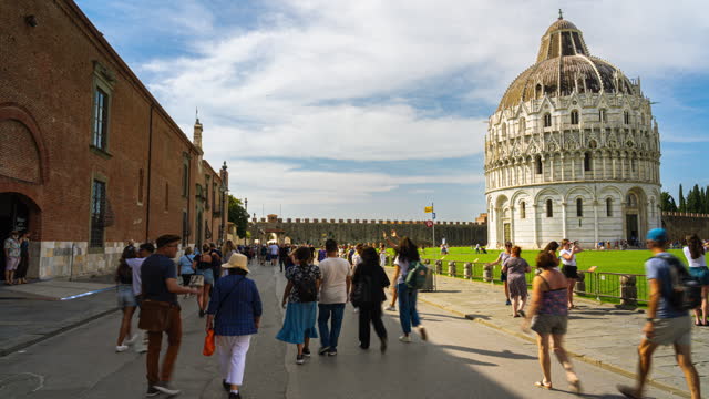 Time lapse of Crowd of People tourism walking and sightseeing attraction at The Pisa Baptistery of St. John around Leaning Tower of Pisa and Pisa Cathedral in summer in Pisa, Tuscany, Italy