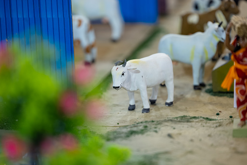 Handmade idol of cow in farming field made with clay. Selective focus.