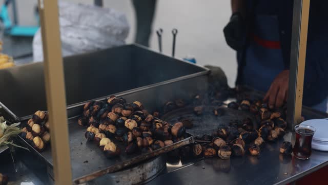 Trukish man sells roasted chestnuts and boiled fragrant corn to tourists - Street food concept