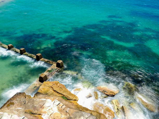 istock Powerful white swirling waves (blurred motion) crashing into rocky coastline 1919406148