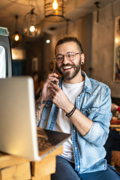 istock Cheerful man working on laptop at coffee shop 1919409296