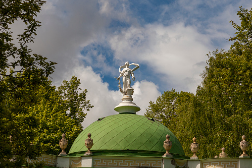 Roof of the pavilion in Moscow Kuskovo park with a white statue.