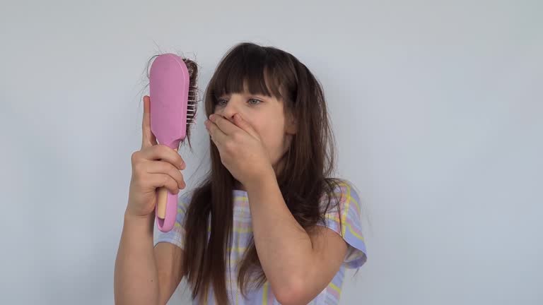 Frightened and shocked girl with long hair holding piece of hair pulled out