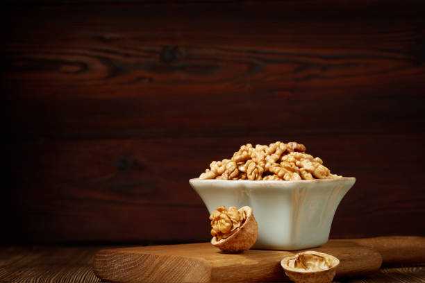 istock A bowl of peeled walnut kernels on a wooden board with copy space. 1919484987