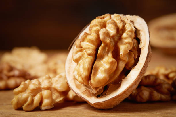 gros plan d’un bouquet de noix sur un fond en bois. macrophotographie. prise de vue en studio. - dried fruit variation healthy eating snack photos et images de collection