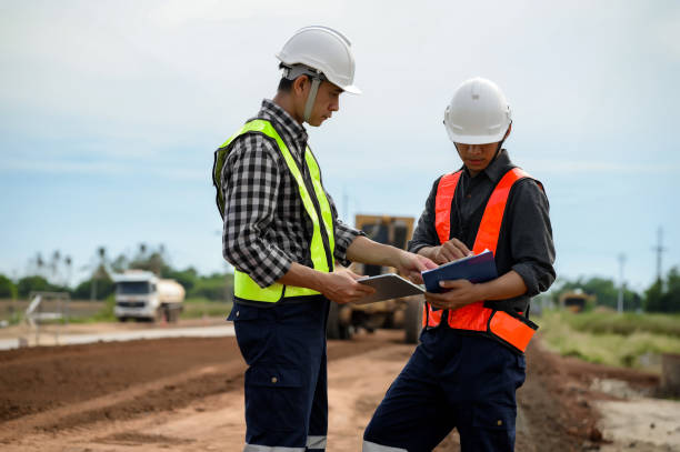 istock Highway engineers discuss plans for construction improvement based on roadworks. Soil Fill, Backfill Compaction for Sub base, Base Course, Surveyor Engineer inspector in highway construction. 1919487877
