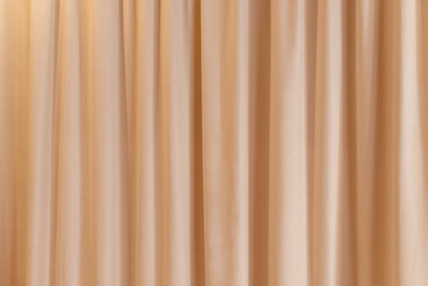 istock peach color color curtain that dropped down as a straight line. Background for inserting text, empty spaces. 1919499172