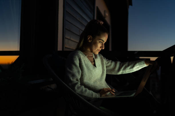istock Young woman using laptop on a balcony with a beautiful view 1919512501
