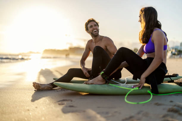 istock Happy couple is laughing, having fun and prepare for surfing. 1919551726