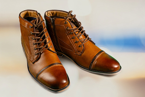 A pair of premium calfskin boots with a multi-colored background. Horizontal shot. Men's shoe ideas.