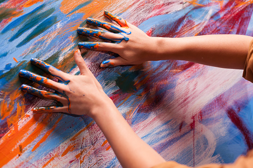 Hands of artist with paint on large canvas in art studio. Modern artwork paint on canvas, creative, contemporary and successful fine art artist drawing masterpiece