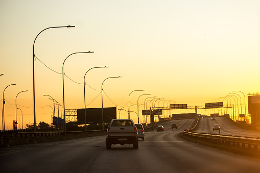 Cars driving down a quiet highway towards the dawn on a weekend in Johannesburg South Africa,