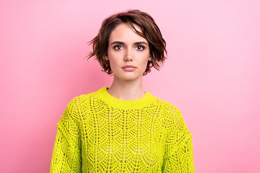 Portrait of confident young woman bob brown hair wearing knitted sweater promoting handmade clothing isolated on pink color background.