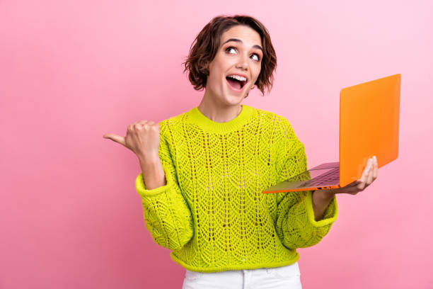 istock Photo of beginner business lady point finger empty space introduce first project using laptop presentation isolated on pink color background 1919629253