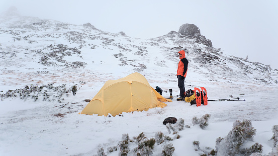 Tourist put up tent with in extreme winter condition in mountains