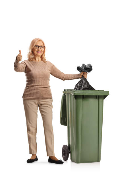 istock Woman throwing a plastic waste bag in a bin and gesturing thumbs up 1919656584
