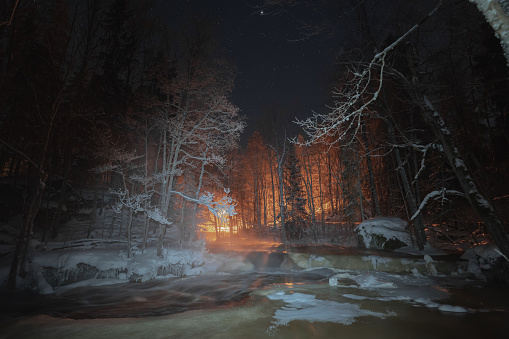 Nature of Estonia in winter. Night scene, frozen forest river. High quality photo