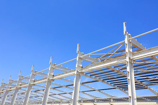 steel girder truss under blue sky, closeup of photo
