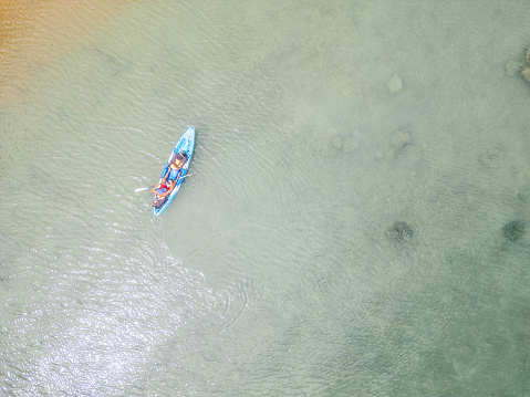 Man in his 60s canoeing in a bay in Southern Thailand enjoying winter in tropical climate.