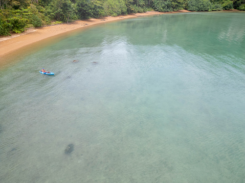 Man in his 60s canoeing in a bay in Southern Thailand enjoying winter in tropical climate.