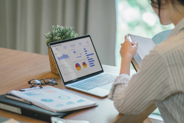 istock Businesswoman accountant using a graphs and charts to analyze market data, balance sheets,accounts,and net profits in order to plan new sales strategies and increase production capacity. 1919717098