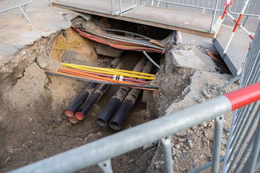 cables are crossing and buried underground on the street. underground electric cable infrastructure installation. Construction site with A lot of communication Cables