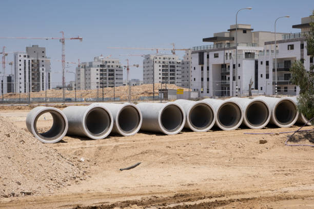 verlegung von abwasser betonentwässerungsrohr auf baustelle zwischen wohngebieten in israel. neuer sanitärkanal, regenwasserkanal - bridge incomplete construction building activity stock-fotos und bilder