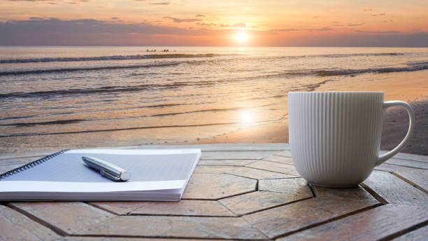 istock Notebook, pens and coffee on a rooftop by the sea 1919723585