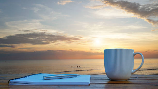istock Notebook, pens and coffee on a rooftop by the sea 1919723604