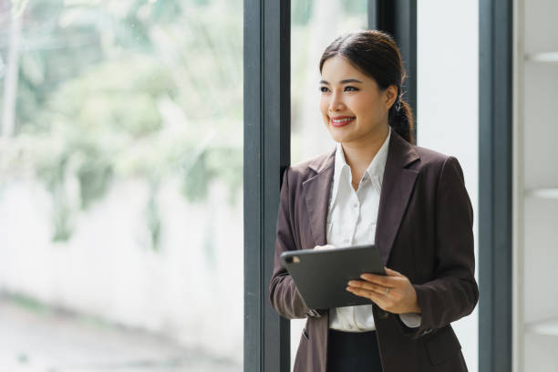 istock Professional Businesswoman standing and using Digital Tablet at modern office. 1919724127
