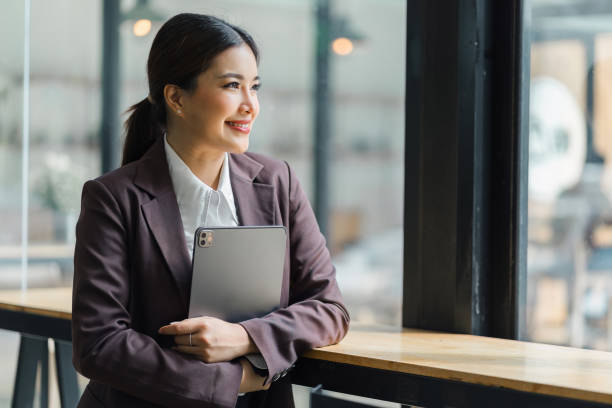 istock Professional Businesswoman standing and using Digital Tablet at modern office. 1919724145