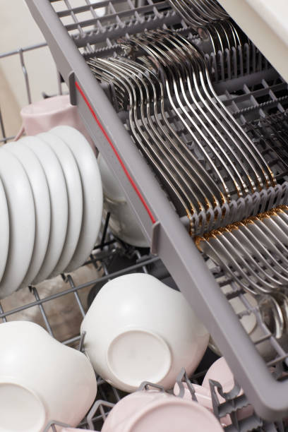 istock Open built-in dishwasher with clean dishes in white kitchen 1919732353