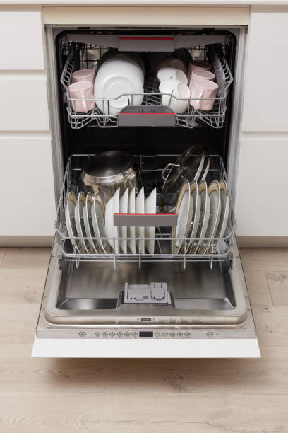 istock Open built-in dishwasher with clean dishes in white kitchen 1919736137