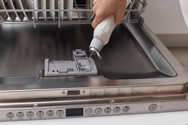istock woman pours rinse aid into the dishwasher compartment 1919736192