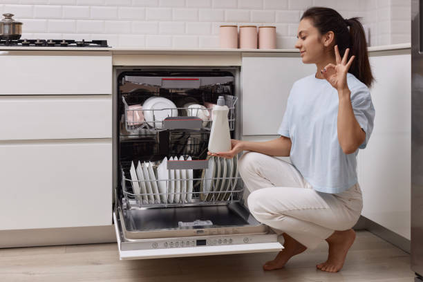 istock woman pours rinse aid into the dishwasher compartment 1919736199