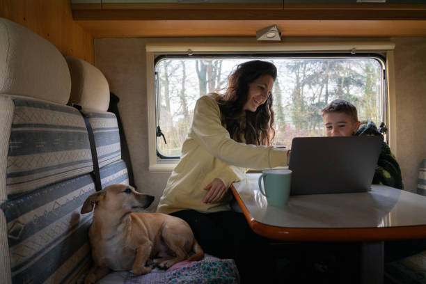 istock Mother with her son and dog looking at the computer inside a motorhome 1919749232