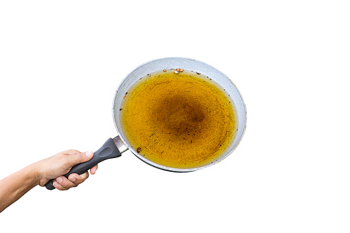 Man holds a iron pan and old vegetable oil Isolated on white background.