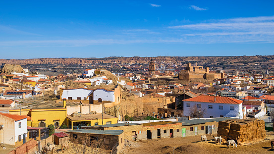 View on Guadix, with the characteristic residential district, the fortress of the Alcazaba, that began to be built around the 10th century, and the cathedral's bell tower