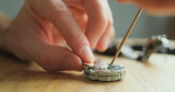 Replacing the battery in an electronic watch. Watchmaker changes the battery in an electronic wrist watch, the inside of the movement, quartz. High quality photo