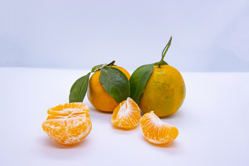 Orange Tangerine Green Citrus Fruit with leaves in isolated white background