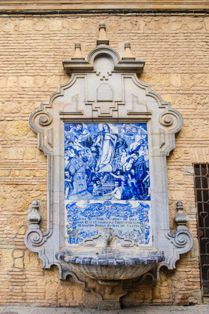Ceramic tilework depicting the Virgin Mary on a Baroque fountain leaning against the wall of the 13th-century Church of San Francisco in the old town of Cordoba