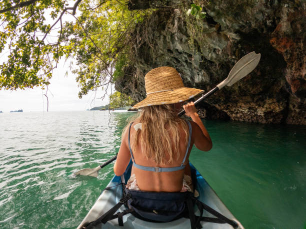 istock Young woman kayaking in tropical setting, rear view 1919809576