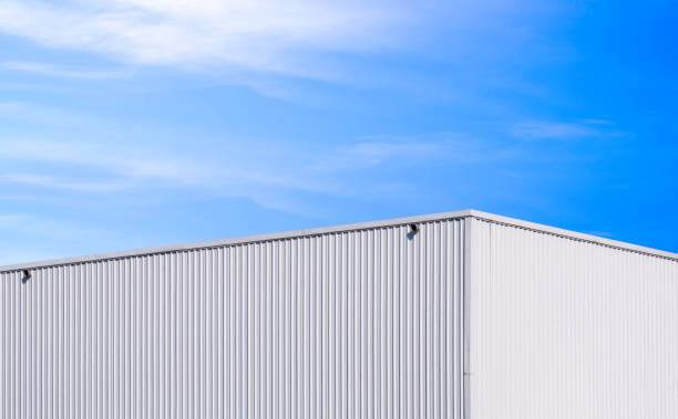 istock Modern white metal industrial warehouse building against blue sky background, perspective side view 1919812337